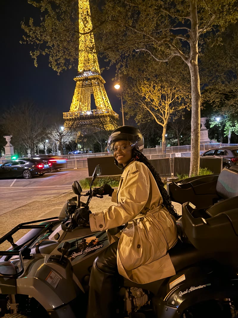 Mima on a quad bike at night near the Eiffel Tower