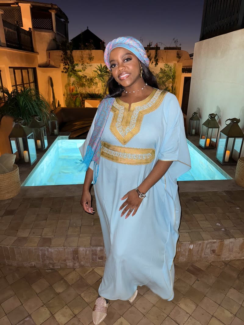 Mima in an embroidered light-blue kaftan on a riad terrace at night