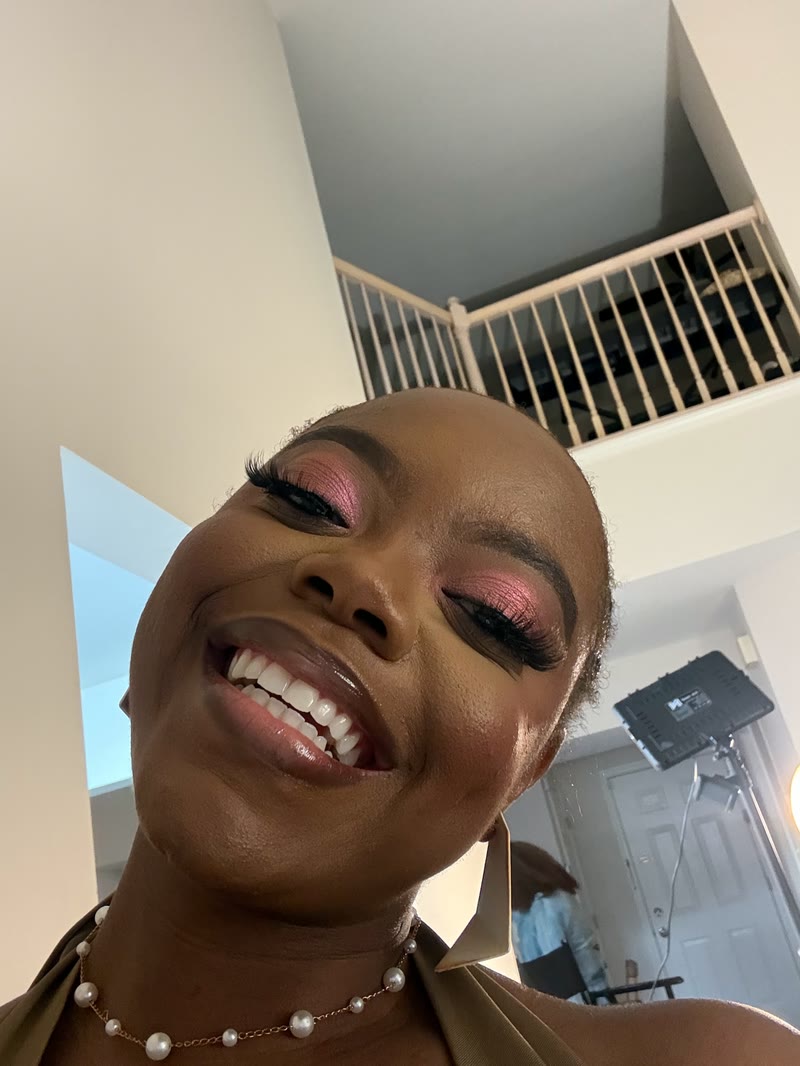 Smiling selfie of Mima wearing pink eye make-up